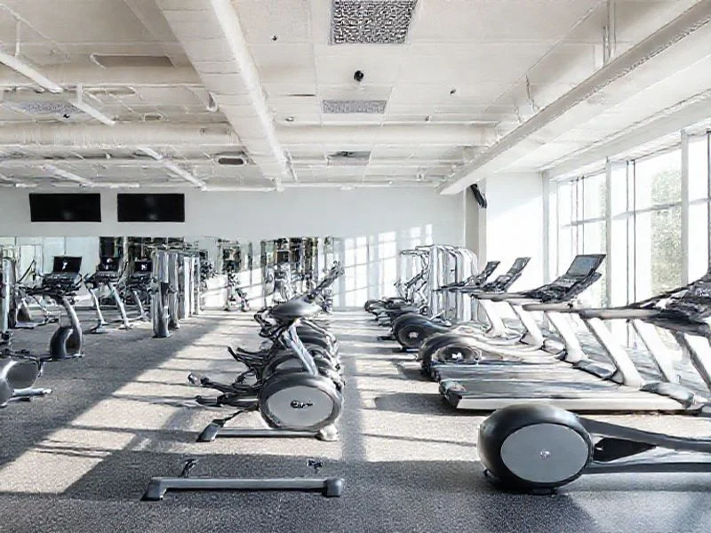 A close-up, macro shot of interwoven carbon fiber textures and precision-machined metallic gears, gleaming under focused directional lighting. The image conveys strength, durability, and intricate engineering. Soft bokeh in the background highlights the foreground detail. Colors lean towards dark grey, silver, and subtle electric aqua accents. No human figures or discernible brand logos.